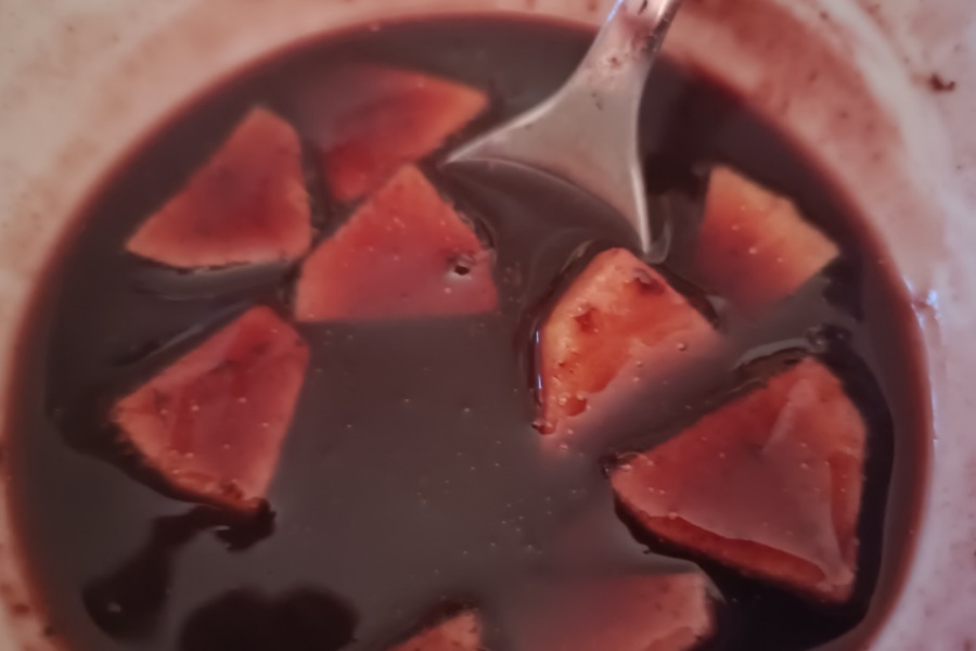 Schüssel mit Holundersuppe, Apfelstückchen und einem Löffel, Verwendung Wildkräuter