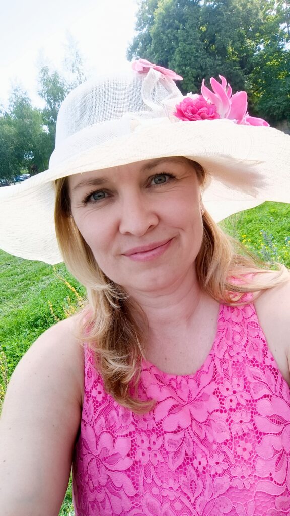 Ein Selfie von mir in einem pinken Kleid und mit beigem Hut bei einer Hochzeit