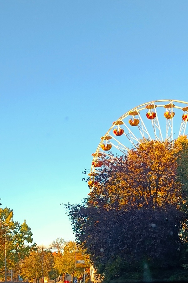 Ein Riesenrad umringt von herbstlich gefärbten Bäumen